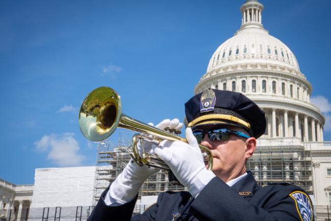 Officer playing trumpet in front of U.S. Capitol