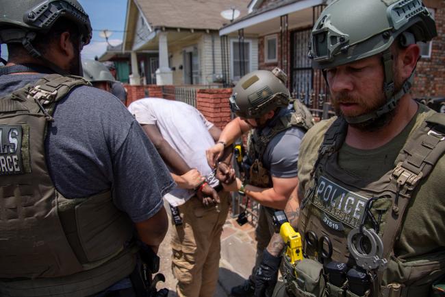 Deputy U.S. Marshals while handcuffing a fugitive during…