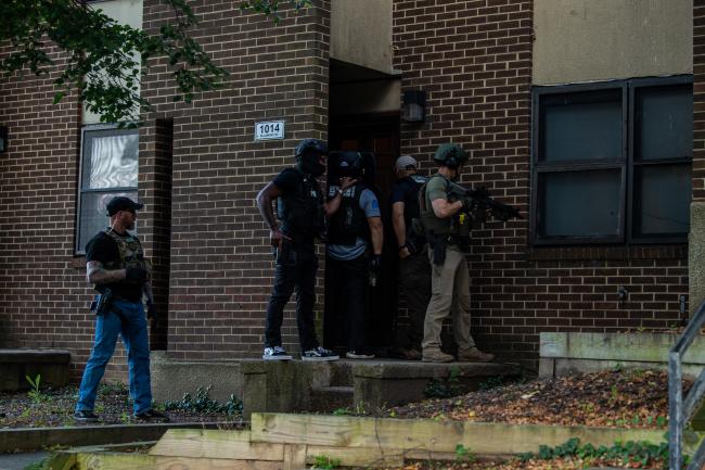 Deputy U.S. Marshals at the front door of a residence…