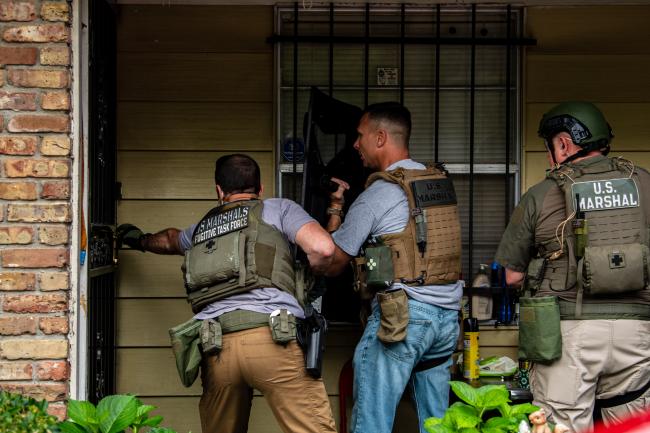 U.S. Deputy Marshals entering a house during Operation…