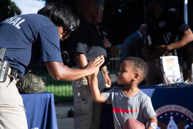 Deputy U.S. Marshal high fiving a child at the 2022…